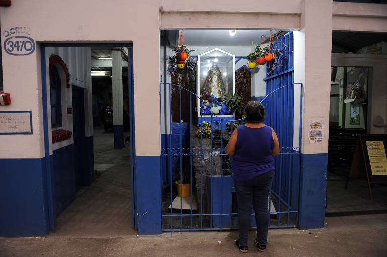 Fiel na porta da paróquia Caacupé , na Villa 21-24