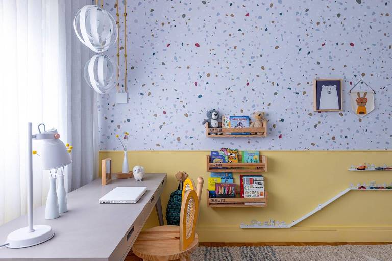 Quarto infantil com a metade inferior da parede pintada de amarelo e a superior, com papel de parede com fundo branco e pintinhas coloridas