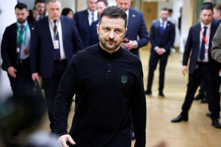 Ukraine's President Volodymyr Zelenskiy walks in a EU headquarters corridor after his meeting with France's President