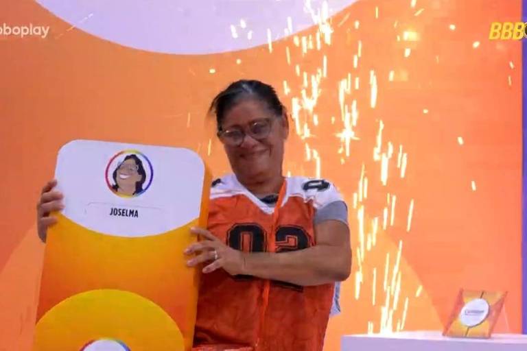 Mulher de laranja e óculos segura card