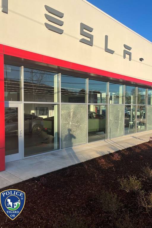 Janelas quebradas por balas em uma concessionária Tesla em Tigard, Oregon.