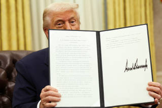U.S. President Donald Trump signs executive orders in the Oval Office, at the White House in Washington, D.C.