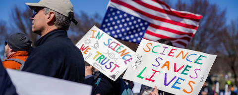 Demonstrators hold signs and an upside-down U.S. flag on the day of a 
