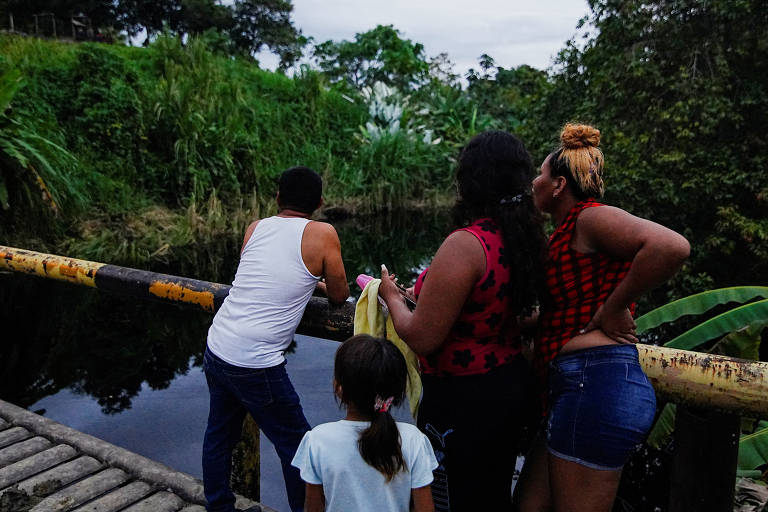 Pessoas observam manchas de petróleo vazado em rio na província de esmeraldas, no Equador