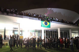 Manifestantes na cúpula do Congresso Nacional durante protestos de junho de 2013