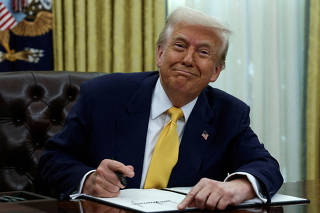 FILE PHOTO: FILE PHOTO: U.S. President Donald Trump signs an executive order in the Oval Office of the White House in Washington