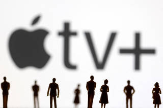 FILE PHOTO: Toy figures of people are seen in front of the displayed Apple TV + logo, in this illustration