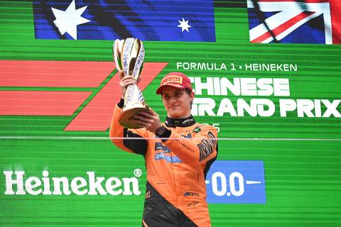 TOPSHOT - McLaren's Australian driver Oscar Piastri celebrates on the podium with his trophy after winning the Formula One Chinese Grand Prix at the Shanghai International Circuit in Shanghai on March 23, 2025. (Photo by JADE GAO / AFP)