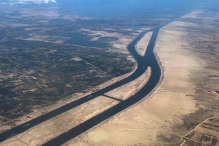 FILE PHOTO: Ships are seen from a plane window, passing through the Suez Canal