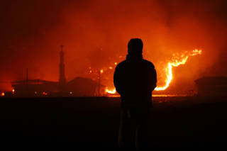 A resident looks on as a wildfire devastates the area in Andong