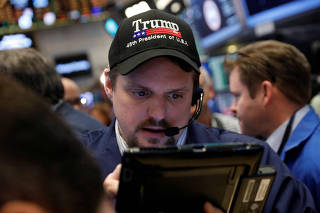 FILE PHOTO: A trader wears a Donald Trump hat while working on the floor of the NYSE shortly after the opening bell in New York