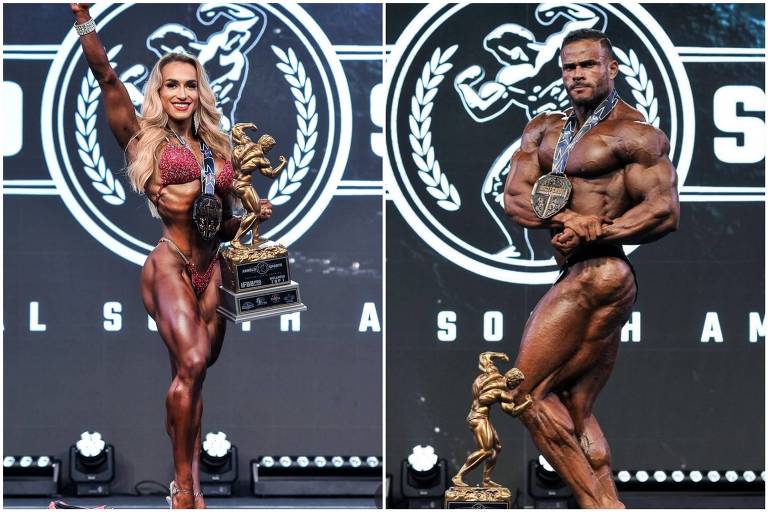 A imagem mostra dois fisiculturistas em um palco de competição. À esquerda, uma mulher com cabelo longo e liso, vestindo um biquíni de competição, segura um troféu e uma medalha. À direita, um homem musculoso, posando em uma posição de destaque, também com uma medalha. Ao fundo, há um logotipo de competição de fisiculturismo.