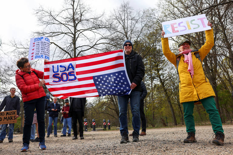 Em Berlim, manifestantes seguraram uma bandeira americana de cabeça para baixo enquanto membros e apoiadores do grupo 'Democratas no Exterior' convocavam outros americanos que vivem na Alemanha a protestar pelo 'fim do caos'