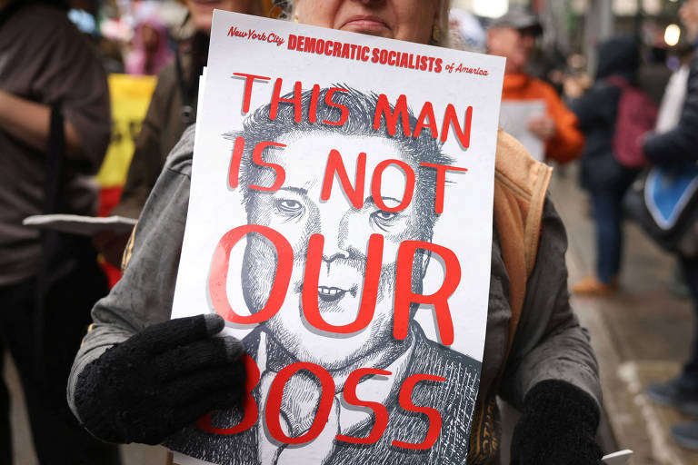 Uma pessoa segura um cartaz em que se lê: 'Este homem não é nosso chefe', em referência a Elon Musk, em Nova York