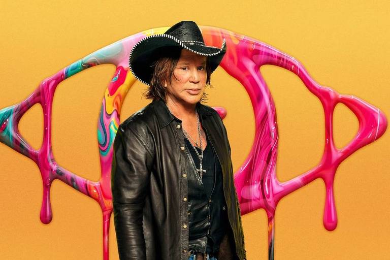 Um homem com cabelo longo e liso, usando um chapéu de cowboy e uma jaqueta preta, está posando em frente a um fundo amarelo com formas coloridas que parecem tinta escorrendo, predominantemente em rosa e azul. O homem tem uma expressão séria e usa um colar com um crucifixo.