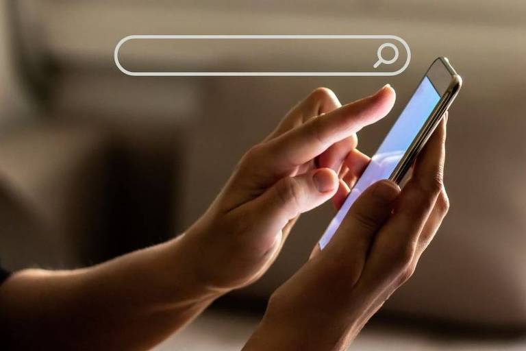 Uma pessoa está segurando um smartphone com uma mão, enquanto a outra mão toca a tela. O fundo é desfocado, sugerindo um ambiente interno. Acima do smartphone, há uma barra de pesquisa visível.
