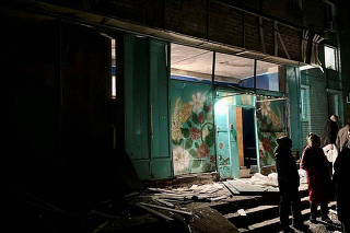 People gather at the site of a Russian mass drone attack at a location given as Dnipro