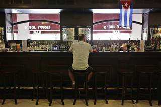 A man sits at the bar in the newly reopened Sloppy Joe's bar in Havana