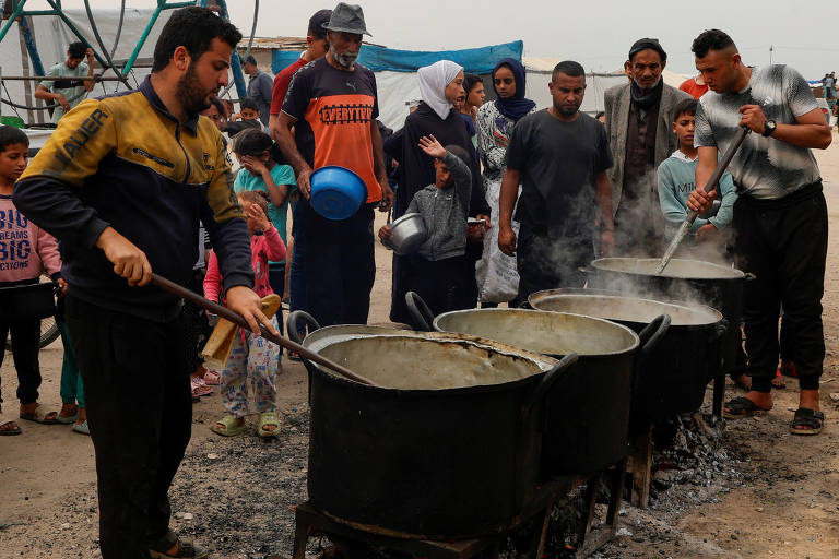 Voluntários preparam comida em campo de refugiados em Khan Younis, no sul de Gaza