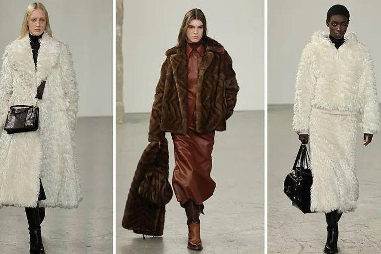 A imagem mostra três modelos desfilando em uma passarela. À esquerda, uma modelo loira usa um casaco longo branco e calças pretas, segurando uma bolsa preta. No centro, uma modelo com cabelo castanho usa um casaco de pele marrom e uma saia longa de couro marrom. À direita, uma modelo com pele escura veste um casaco branco de pele e uma saia longa, também segurando uma bolsa preta. O fundo é neutro e minimalista, destacando as roupas.