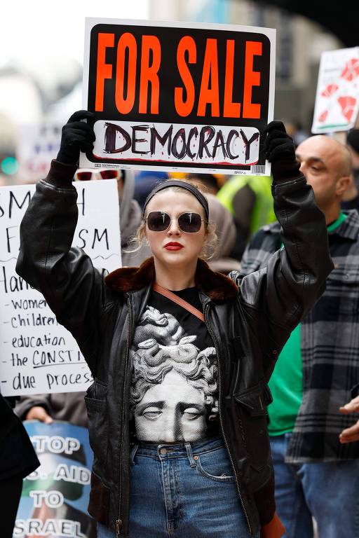 Manifestante segura cartaz em protesto contra as políticas do presidente Donald Trump no centro de Chicago, Illinois