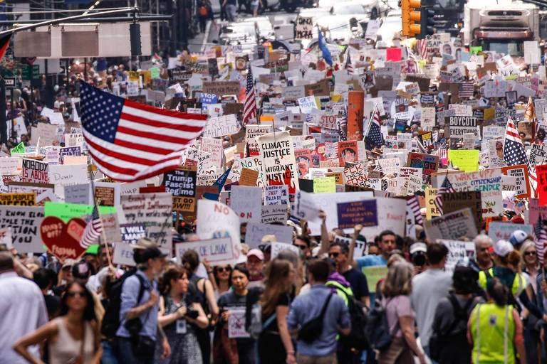 Manifestantes participam do protesto contra as políticas do atual presidente amerciano Donald Trump a respeito de imigrantes e a crise climática em Nova York; atos contra o governo tomaram as ruas de várias cidades dos Estados Unidos