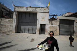 A Palestinian woman walks outside the Holy Family Church after the death of Pope Francis was announced by the Vatican, in Gaza City