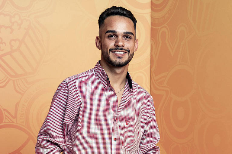 Homem branco de camisa quadriculada sorri