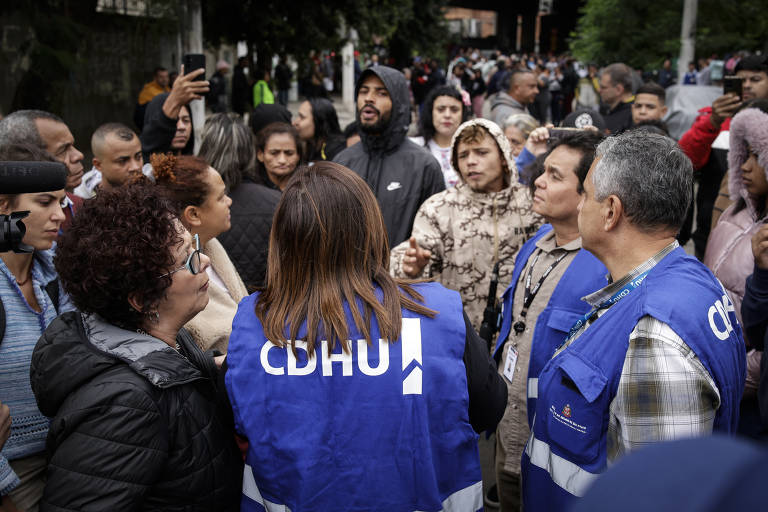 Funcionários da CDHU conversam com moradores na favela do Moinho