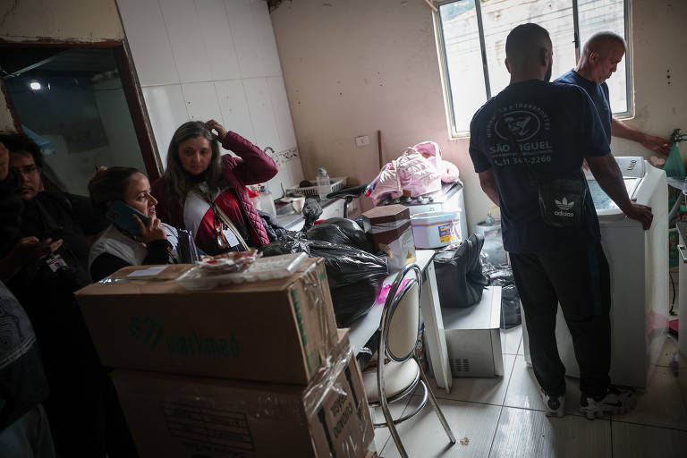 Agentes da CDHU na casa de uma das famílias para a retirada dos móveis e pertences