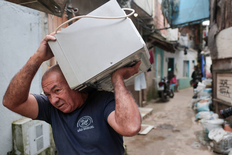 Funcionário carrega pertences de uma das famílias que aceitou deixar a favela do Moinho no primeiro dia de retirada de moradores do local