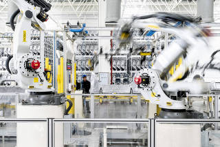 Robots and a worker at a factory of the electric carmaker Zeekr in Ningbo, China, March 31, 2025. (Qilai Shen/The New York Times)