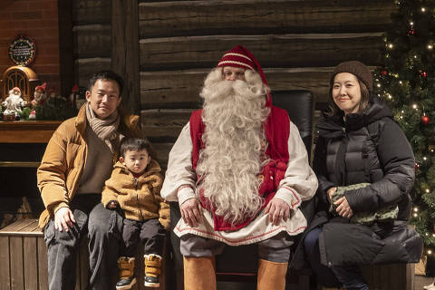 Tourists have their picture taken with one of the Santas at Santa Claus Village outside Rovaniemi, Finland, Feb. 23, 2025. A tourist season that stretches from October to March has been anything but jolly for some residents of the ?Official Hometown of Santa Claus.? (Jim Huylebroek/The New York Times) ORG XMIT: XNYT0532 DIREITOS RESERVADOS. NÃO PUBLICAR SEM AUTORIZAÇÃO DO DETENTOR DOS DIREITOS AUTORAIS E DE IMAGEM