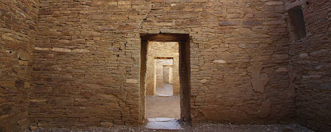 Paredes interiores com vigas de madeira expostas e portas alinhadas em Pueblo Bonito, no Chaco Culture National Historical Park, no Novo México, EUA