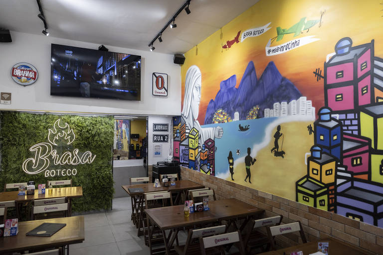 A imagem mostra o interior de um boteco chamado 'Brasa Botecco'. À esquerda, há uma parede verde com o nome do boteco em destaque. À direita, uma parede colorida apresenta uma pintura com elementos da cidade, incluindo montanhas, casas e pessoas. No fundo, há uma televisão montada na parede e mesas de madeira dispostas no espaço.