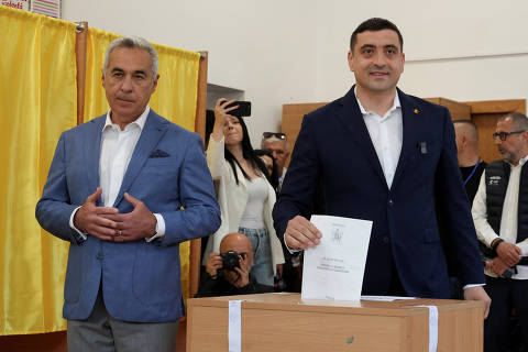 Presidential candidate George Simion votes as Calin Georgescu looks on at a polling station during the country's first round of the presidential election, in Mogosoaia, Romania, May 4, 2025. REUTERS/Louisa Gouliamaki ORG XMIT: LIVE