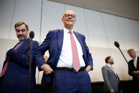 CSU Bavarian Premier Markus Soeder and incoming German Chancellor Friedrich Merz of CDU, react, ahead of a Bundestag CDU/CSU fraction meeting, where a new chair will be elected, in Berlin, Germany, May 5, 2025. REUTERS/Liesa Johannssen REFILE - CORRECTING EVENT FROM 