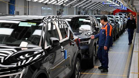 Workers inspect cars at the end of the production line of the Volvo factory in Ghent on April 25, 2025. This factory will produce the Volvo X30 100% electric model for the European market. (Photo by Nicolas TUCAT / AFP)