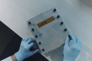 A worker at Factorial Energy with a new kind of electric vehicle battery that can charge faster, in Billerica, Mass., a suburb of Boston, Oct. 2, 2024. (Tony Luong/The New York Times)