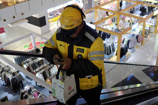 Delivery worker picks up a food order at a shopping mall in Beijing