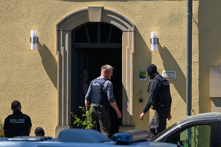 Police officers search the headquarters of far-right organization 