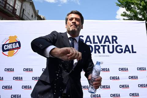 Leader of far-right Chega party, Andre Ventura sprinkles supporters with water during a campaign rally in Braga, northern Portugal, on May 8, 2025, ahead of legislative elections. (Photo by MIGUEL RIOPA / AFP)