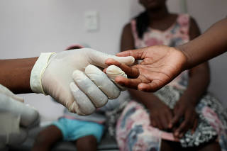 A nurse takes a blood sample from a child for an HIV test at a clinic in Diepsloot