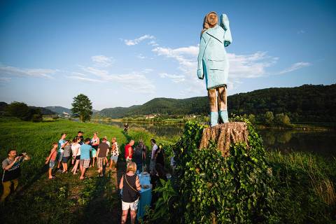 (FILES) People gather around what conceptual artist Ales 'Maxi' Zupevc claims is the first ever monument of Melania Trump, set in the fields near the town of Sevnica, US First Ladys hometown, during a small inauguration celebration on July 5, 2019. Slovenian police are investigating the disappearance of a bronze statue of US First Lady Melania Trump, which was stolen near her Slovenian hometown, they said on May 15, 2025. The life-sized statue of her by American conceptual artist Brad Downey was unveiled near her hometown of Sevnica in 2020, towering on a tree stump over a field, after a previous statue, made of wood, was burnt down by unknown arsonists. But now it has disappeared -- cut above the ankles -- according to the artist and police. (Photo by Jure Makovec / AFP) / RESTRICTED TO EDITORIAL USE - MANDATORY MENTION OF THE ARTIST UPON PUBLICATION - TO ILLUSTRATE THE EVENT AS SPECIFIED IN THE CAPTION