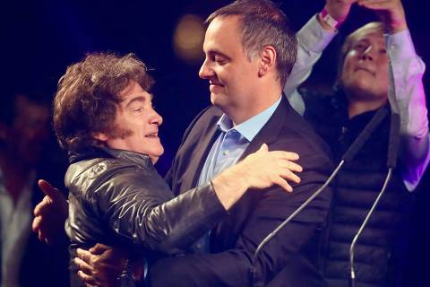 Argentina's President Javier Milei (L) embraces Presidency Spokesman and legislative candidate Manuel Adorni during his closing campaign rally in Buenos Aires on May 14, 2025. Buenos Aires City will hold legislative elections on May 18. (Photo by STRINGER / AFP)
