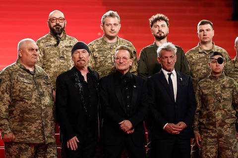 Bono, The Edge and Sean Penn pose on the red carpet with Ukrainian servicemen, during arrivals for the screening of the documentary film 