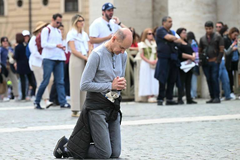Um fiel reza durante a missa pelo início do pontificado do Papa Leão 14, na Praça de São Pedro