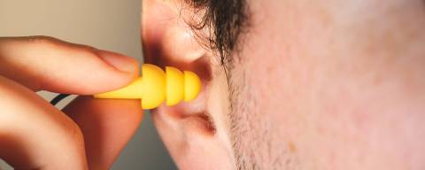 Man worker inserting yellow hearing safety protection earplug in his ear close up view
( Foto: Keitma / adobe stock ) DIREITOS RESERVADOS. NÃO PUBLICAR SEM AUTORIZAÇÃO DO DETENTOR DOS DIREITOS AUTORAIS E DE IMAGEM