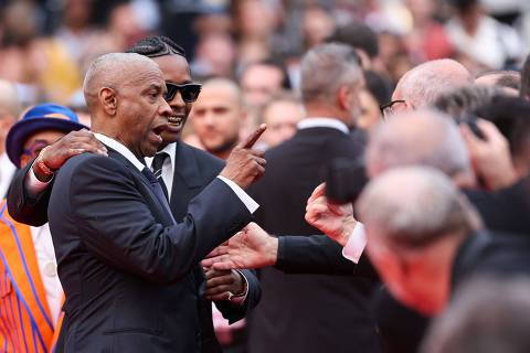 US actor Denzel Washington argues with a photographer next to US singer and actor ASAP Rocky as they arrive for the screening of the film 