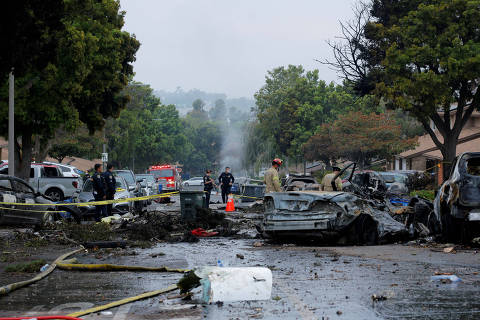 Emergency personnel work at the crash scene on a street, after a small civilian aircraft went down in a neighborhood in San Diego, California, U.S. May 22, 2025.  REUTERS/Mike Blake     TPX IMAGES OF THE DAY ORG XMIT: LIVE